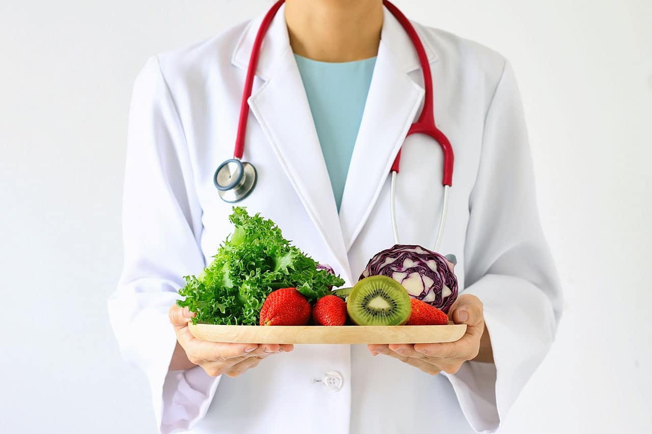 Woman Chopping Healthy Vegetables on a Cutting Board